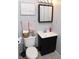 Well-lit bathroom with a vanity, toilet, and pink accents, offering a clean and functional space at 6616 W 15Th St, Indianapolis, IN 46214