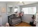 Charming Bedroom with a gray crib, wooden floors, and bright windows for a cheerful and comforting space at 6616 W 15Th St, Indianapolis, IN 46214