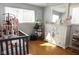 Bright Bedroom with a crib, dresser, and large windows, creating a cozy and functional space for a little one at 6616 W 15Th St, Indianapolis, IN 46214