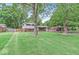 Well-maintained home surrounded by mature trees and lush green lawn at 6616 W 15Th St, Indianapolis, IN 46214