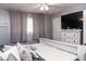 Bedroom with neutral tones featuring a bed, large windows, and a dresser with a television at 6616 W 15Th St, Indianapolis, IN 46214