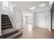 Bright foyer with wood floors, staircase, chandelier, skylight, and views into adjacent room at 6677 W Longview Dr, McCordsville, IN 46055