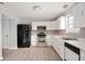 Updated kitchen featuring white cabinets, stainless steel appliances, granite countertops, gray backsplash, and wood-look flooring at 6677 W Longview Dr, McCordsville, IN 46055