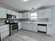 Modern kitchen with gray backsplash and stainless steel appliances at 6677 W Longview Dr, McCordsville, IN 46055