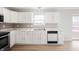 Updated kitchen with white cabinets, marble countertops, gray backsplash, stainless appliances, and wood-look floors at 6677 W Longview Dr, McCordsville, IN 46055