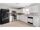 Updated kitchen featuring white cabinets, stainless steel appliances, granite countertops, and wood-look flooring at 6677 W Longview Dr, McCordsville, IN 46055