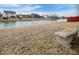 Scenic pond view with stone bench, grassy shoreline and homes in the background at 6677 W Longview Dr, McCordsville, IN 46055