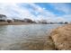 Calm pond view surrounded by grassy shoreline with neighborhood homes in the distance at 6677 W Longview Dr, McCordsville, IN 46055