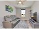 Cozy bedroom featuring a gray leather reclining sofa, ceiling fan, and television at 6919 Sable Point Dr, Brownsburg, IN 46112