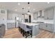 Bright kitchen features a large island with seating, stainless steel appliances, and modern gray cabinetry at 6919 Sable Point Dr, Brownsburg, IN 46112