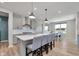 Open-concept kitchen with gray cabinets, stainless appliances, and island seating adjoins the dining area at 6919 Sable Point Dr, Brownsburg, IN 46112