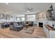Spacious living room featuring a large gray sofa, fireplace, ceiling fan, and views of the kitchen at 6919 Sable Point Dr, Brownsburg, IN 46112