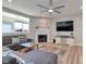 Bright living room features a large gray sofa, fireplace, ceiling fan, and views to the neighborhood at 6919 Sable Point Dr, Brownsburg, IN 46112