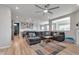 Open living room with large gray sofa, ceiling fan, fireplace, and view to the kitchen at 6919 Sable Point Dr, Brownsburg, IN 46112
