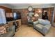 Comfortable living room featuring brick accent wall, tiled floor, and two plush armchairs at 70 Joseph Ln, Whiteland, IN 46184