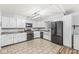 Kitchen features tile flooring, white cabinets, modern lighting, and stainless steel appliances at 714 School St, Greenfield, IN 46140
