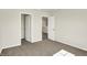 A carpeted bedroom featuring two doors and an open closet with shelving at 7168 Jackson Dr, Cumberland, IN 46229