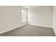 Bright bedroom featuring a window, neutral walls, and soft carpet at 7168 Jackson Dr, Cumberland, IN 46229