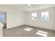 Upstairs bonus room with neutral carpet, two windows, and an open doorway at 7168 Jackson Dr, Cumberland, IN 46229