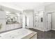 Spacious bathroom featuring a glass enclosed shower and a soaking tub, providing an elegant and relaxing space at 720 S Rangeline Rd # 703, Carmel, IN 46032