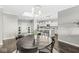 Dining area with round table and chairs, leading to a modern open kitchen with white cabinetry at 720 S Rangeline Rd # 703, Carmel, IN 46032
