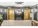 Elegant elevator lobby with gold elevators, modern lighting fixtures, and marble floors at 720 S Rangeline Rd # 703, Carmel, IN 46032
