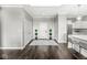 Inviting foyer with dark wood floors, decorative topiaries, and access to the kitchen at 720 S Rangeline Rd # 703, Carmel, IN 46032