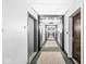 Well-lit hallway with carpet runner and doors on either side at 720 S Rangeline Rd # 703, Carmel, IN 46032