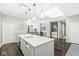 Open kitchen with large island, pendant lights, stainless appliances, seamlessly connected to dining and living areas at 720 S Rangeline Rd # 703, Carmel, IN 46032