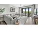 Bright living room with modern furnishings, art, and a sliding door to a balcony with treetop views at 720 S Rangeline Rd # 703, Carmel, IN 46032