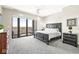 Inviting bedroom with a dark wood sleigh bed, a ceiling fan, and private balcony with scenic views at 720 S Rangeline Rd # 703, Carmel, IN 46032