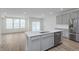 Open kitchen boasts stainless steel appliances, a center island with sink, and gray cabinets at 7324 Shroyer Way, Noblesville, IN 46062