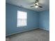 This bedroom features soft blue walls, plush carpeting and a bright window for natural lighting at 7332 Jackie Ct, Indianapolis, IN 46221