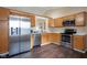 Well-lit kitchen featuring stainless steel appliances, wood cabinets, and durable hardwood floors at 7332 Jackie Ct, Indianapolis, IN 46221