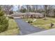 Brick ranch home with an attached garage, walkway, and mature landscaping at 7481 Holliday E Dr, Indianapolis, IN 46260