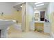 A bathroom with a toilet and bath, light yellow tiling and modern countertop at 7481 Holliday E Dr, Indianapolis, IN 46260