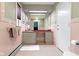 A bathroom with a toilet, sink and vanity, pink tiling and an updated heater at 7481 Holliday E Dr, Indianapolis, IN 46260