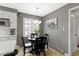 Bright dining area with a dark round table, with large windows and a view outside at 7481 Holliday E Dr, Indianapolis, IN 46260