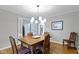 Dining room with wood table and chairs with chandelier and doors to the living room at 7481 Holliday E Dr, Indianapolis, IN 46260