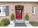 Elegant red double door flanked by planters and brick surround at 7481 Holliday E Dr, Indianapolis, IN 46260
