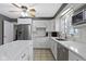 White kitchen featuring stainless steel appliances, light countertops, and a view of the breakfast bar at 7481 Holliday E Dr, Indianapolis, IN 46260