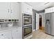 Spacious kitchen with modern appliances and white cabinetry, adjacent to a doorway at 7481 Holliday E Dr, Indianapolis, IN 46260