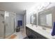Elegant bathroom with double sinks, a modern vanity, and a glass-enclosed shower with beautiful blue accents at 839 N Park Trail Dr, Carmel, IN 46032
