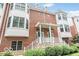Brick townhome with white trim, green doors, a stone foundation, and neatly trimmed shrubs at 839 N Park Trail Dr, Carmel, IN 46032