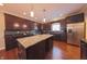 Stylish kitchen boasts dark cabinetry, stainless steel appliances, an island, and hardwood floors at 839 N Park Trail Dr, Carmel, IN 46032