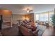Spacious living room with hardwood floors, leather sofas, a staircase, and large bay windows at 839 N Park Trail Dr, Carmel, IN 46032