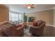 Comfortable living room boasts hardwood floors, two leather sofas, ceiling fan, and neutral paint at 839 N Park Trail Dr, Carmel, IN 46032