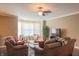 Sunlit living room with hardwood floors, leather sofas, a ceiling fan, and bay window seating at 839 N Park Trail Dr, Carmel, IN 46032