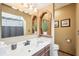 Bathroom with a white counter, mirror, wood vanity and a toilet in an earth tone decorated room at 9132 Log Run N Dr, Indianapolis, IN 46234