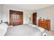 Bedroom with wood closet doors, gray walls, dresser, and a metal bed frame with gray bedding at 9132 Log Run N Dr, Indianapolis, IN 46234